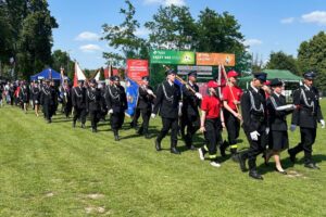 Strażacy maszerujący ze sztandarami