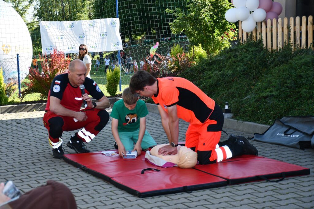 Młodzież ćwicząca RKO pod nadzorem ratownika medycznego
