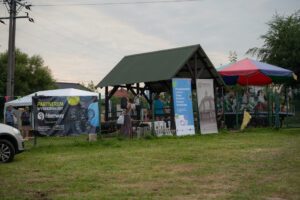 Uczestnicy zabawy przy altanie piknikowej oraz dziecięcej karuzeli.