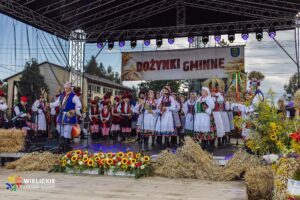 Scena dożynek z mieszkańcami w strojach ludowych